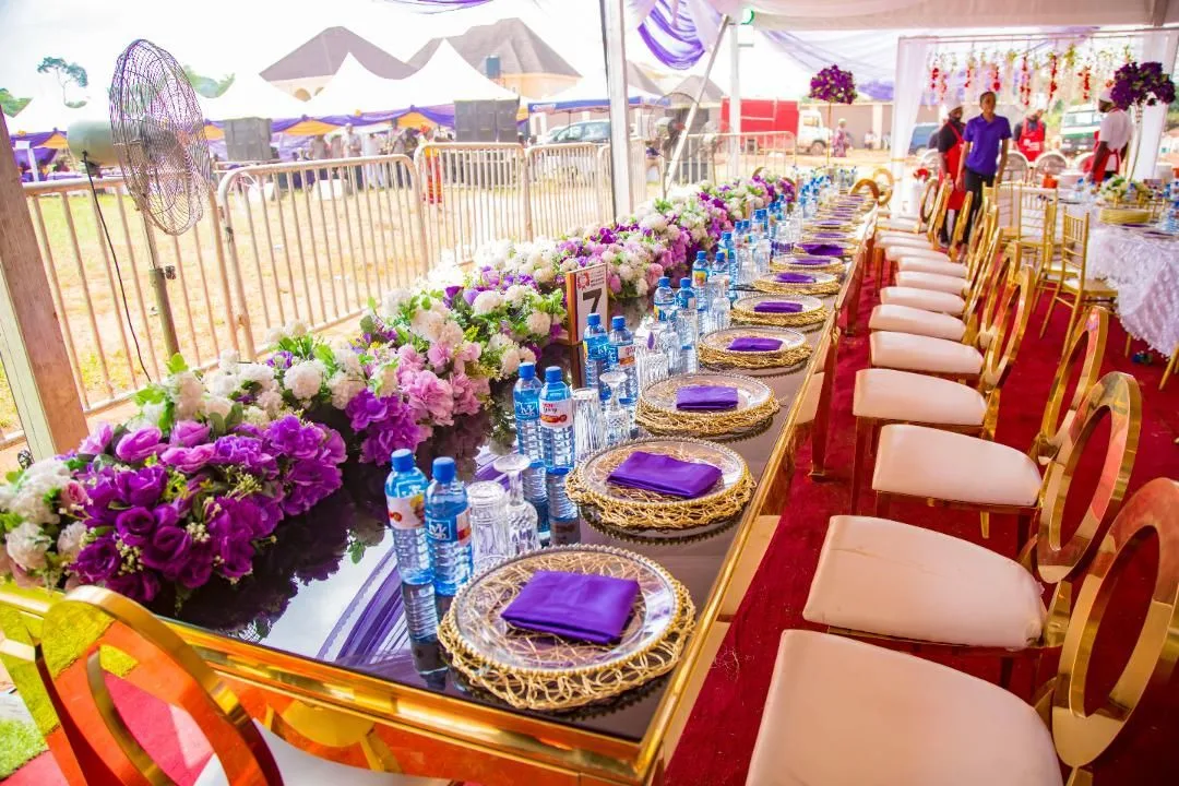 Close view of a purple-and-gold event tablescape with floral centrepiece